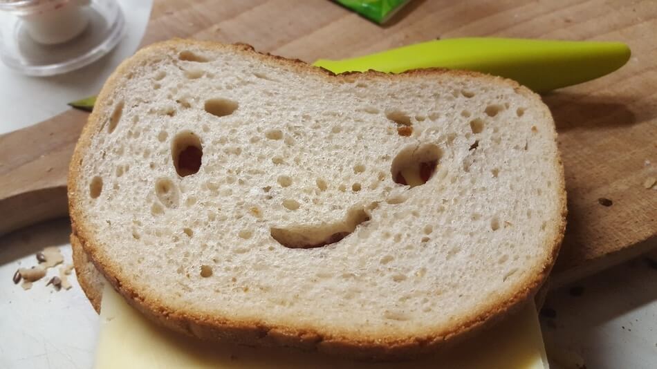 A funny piece of bread with a smiley face on it