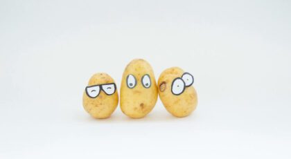 Three potatoes with funny looking eyes drawn on them