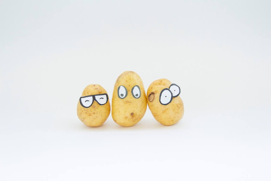 Three potatoes with funny looking eyes drawn on them