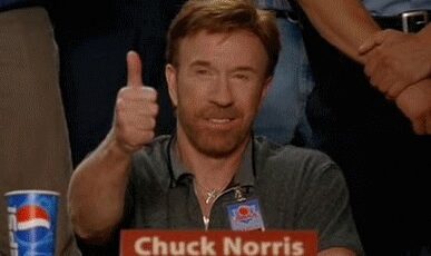 Chuck Norris smiles and gives a thumbs up.